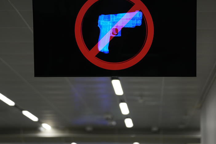 A television displays a "no guns" sign at the Transportation Security Administration security area at the Hartsfield-Jackson Atlanta International Airport on Wednesday, Jan. 25, 2023, in Atlanta. Last year saw a record number of guns intercepted at airport checkpoints across the country.