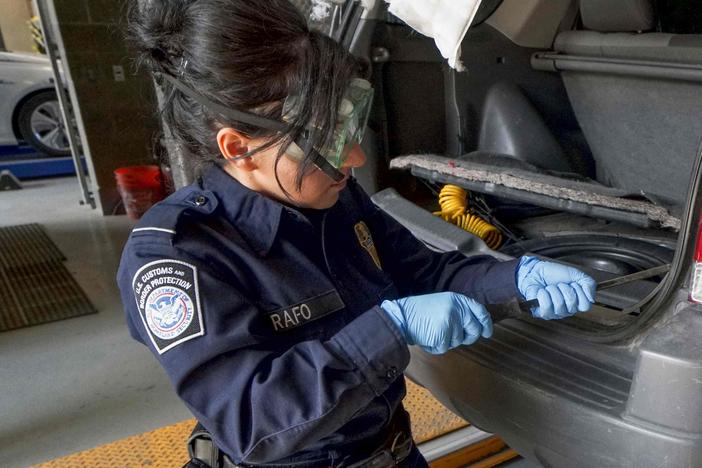 A U.S. Customs and Border Protection agent searches an automobile for contraband in the line to enter the United States at the San Ysidro Port of Entry in October 2019 in San Ysidro, Calif.