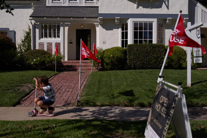 A child rides a scooter past an open house in Los Angeles.