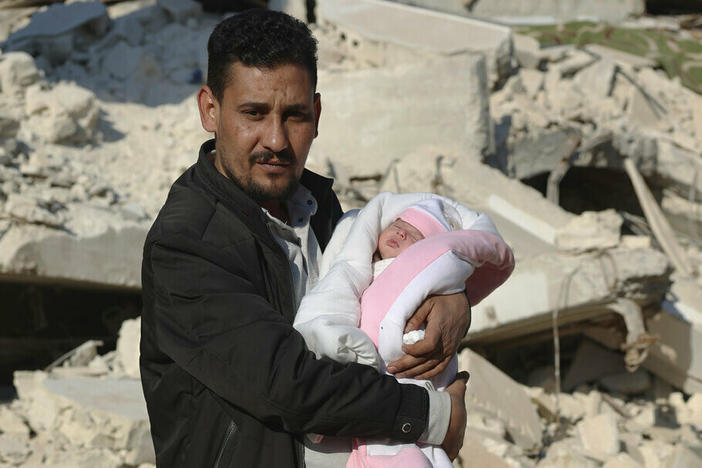 Khalil al-Sawadi holds Afraa, a baby girl who was born under the rubble caused by an earthquake that hit Syria and Turkey, on Monday in the town of Jinderis, Aleppo province, Syria.