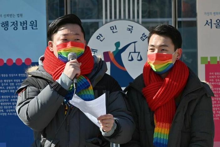 So Seong-uk, left, speaks at a press conference while his partner Kim Yong-min looks on in February 2021 as they file a lawsuit against South Korea's National Health Insurance Service at the Seoul Administrative Court.