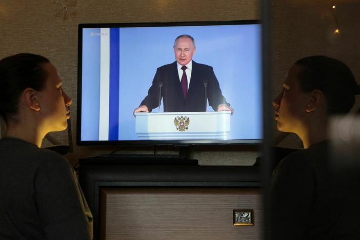 A woman in Simferopol, Crimea, watches a TV broadcast of Russian President Vladimir Putin's annual state of the nation address on Tuesday. Putin announced Russia is suspending participation in the New START nuclear weapons treaty.