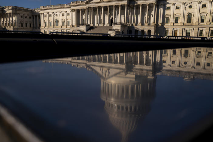 The dome of the U.S. Capitol building is visible in a reflection on Capitol Hill in Washington, D.C., Jan. 23, 2023.