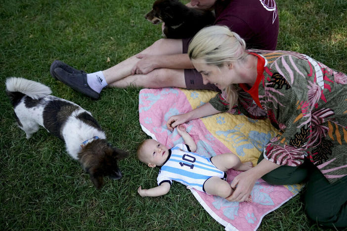 Russian nationals Alla Prigolovkina, her husband Andrei Ushakov, their Argentine-born son Lev Andres and their dogs Santa and Cometa visit a park Feb. 14 in Mendoza, Argentina. In spite of the language barrier and the stifling summer heat, Prigolovkina and Ushakov have quickly adopted Argentine customs since their July move.