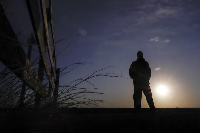 Lateef Dowdell watches the sunrise on Jan. 14, 2021, from what remains of land once belonging to his uncle Gil Alexander, who was the last active Black farmer in the community of Nicodemus, Kan.