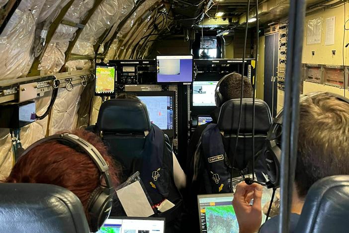 IMPACTS mission researchers inside the research plane, monitoring weather data being collected by onboard instruments.