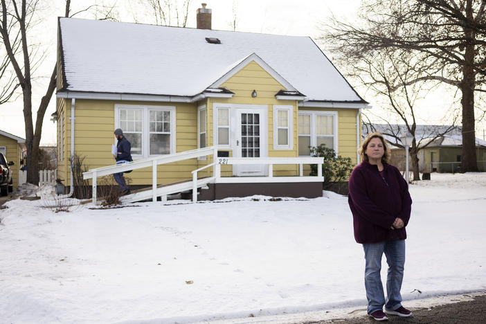 Jen Coghlan outside the home where she grew up in Perry, Iowa. Her father, Henry Ruhl, plans to leave the house to her, but Coghlan expects she'll have to sell it after he dies to settle a $226,611 from Medicaid for the care of her mother, who died in 2022. Coghlan says the family didn't realize that her mother was on Medicaid.