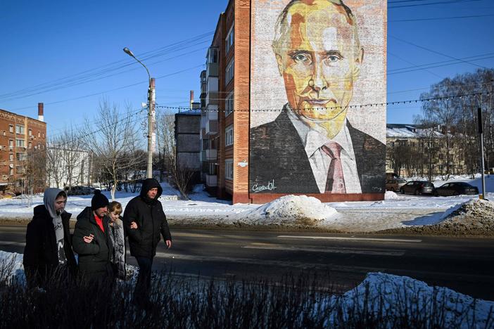 Pedestrians walk past a large mural of Russian President Vladimir Putin on a residential building in Kashira, a town south of Moscow, on Thursday.