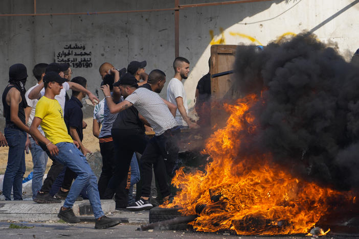 Palestinian demonstrators clash with the Israeli army while forces carry out an operation in the West Bank town of Nablus, on Aug. 9, 2022.