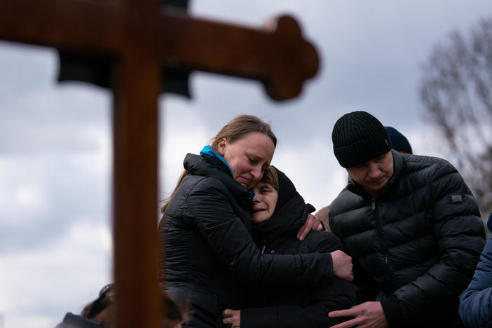 Ukrainian journalist-turned-soldier Viktor Dudar's mother (center) grieves at his grave as he's laid to rest in Lviv, Ukraine, last March. Last week the world marked the first anniversary of Russia's large-scale invasion of Ukraine.