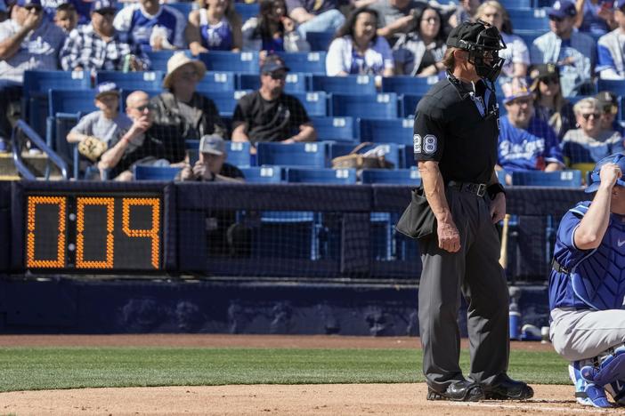 Home plate umpire Jim Wolf waits as the pitch clock counts down during the first inning of a spring training baseball game between the Milwaukee Brewers and the Los Angeles Dodgers Saturday in Phoenix.