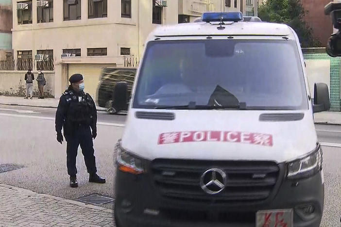 In this image taken from video footage run by TVB Hong Kong, journalists film a police van believed to be carrying relatives of murdered model Abby Choi on its arrival at the Kowloon City Law Courts Building in Hong Kong, Monday, Feb. 27, 2023.