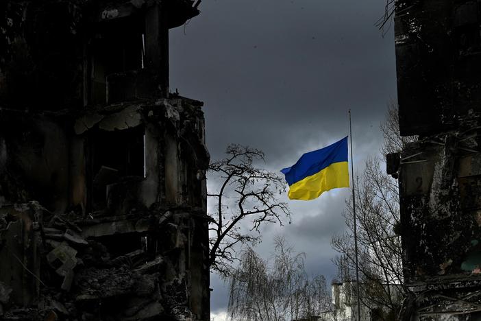 The Ukrainian flag flutters between buildings destroyed in bombardment in the Ukrainian town of Borodianka. It was one year ago last week that Russia invaded.