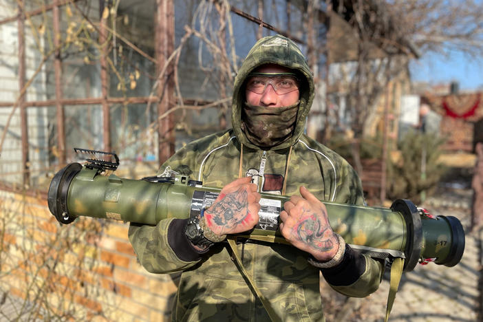 Max, 33, a Ukrainian sniper, poses in the backyard of the reconnaissance team's safe house in the eastern Ukrainian city of Kramatorsk. He's holding a "trophy" — an antitank missile taken off Russian soldiers.