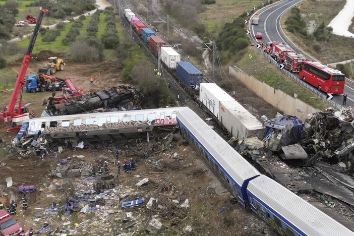 A crane, firefighters and rescuers operate after a collision in Tempe near Larissa city, Greece, Wednesday, March 1, 2023.