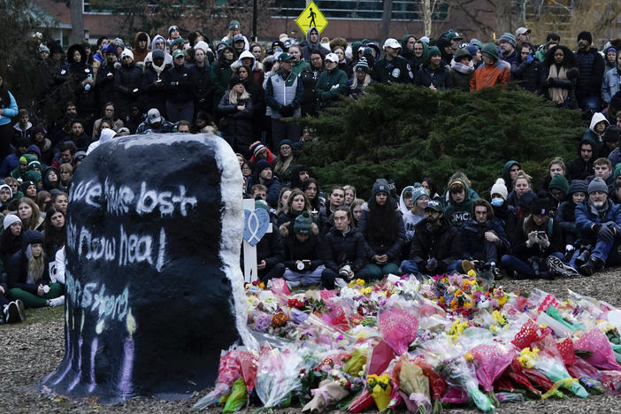 Mourners sit at The Rock on the grounds of Michigan State University in East Lansing, Mich., Wednesday, Feb. 15, 2023. Alexandria Verner, Brian Fraser and Arielle Anderson were killed and several other students remain in critical condition after a gunman opened fire on the campus of Michigan State University Monday night.