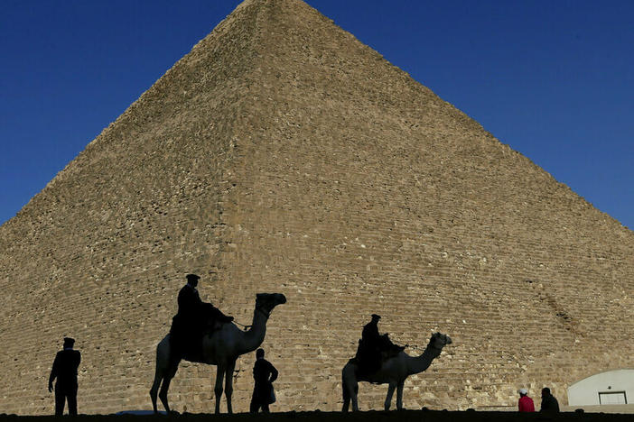 Policemen are silhouetted against the Great Pyramid in Giza, Egypt, in 2012.