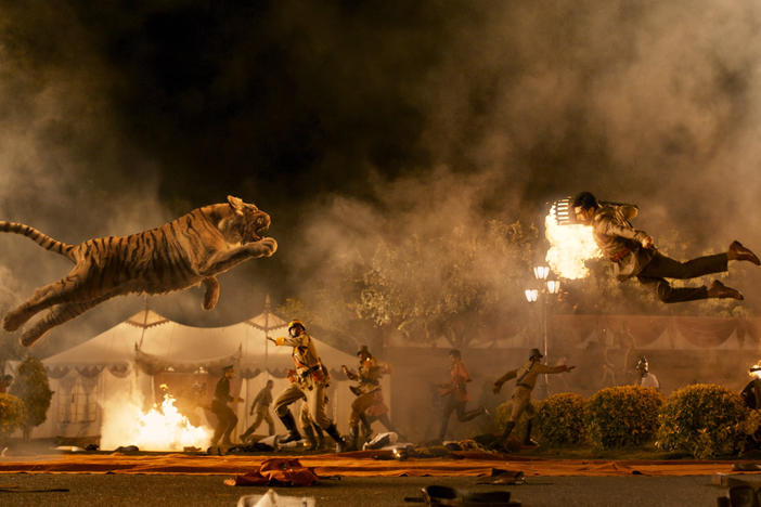 "Naatu Naatu" from the film <em>RRR</em> is up for best original song at the 95th Academy Awards. The tiger flying in the air toward Ram Charan (right), however, is not.