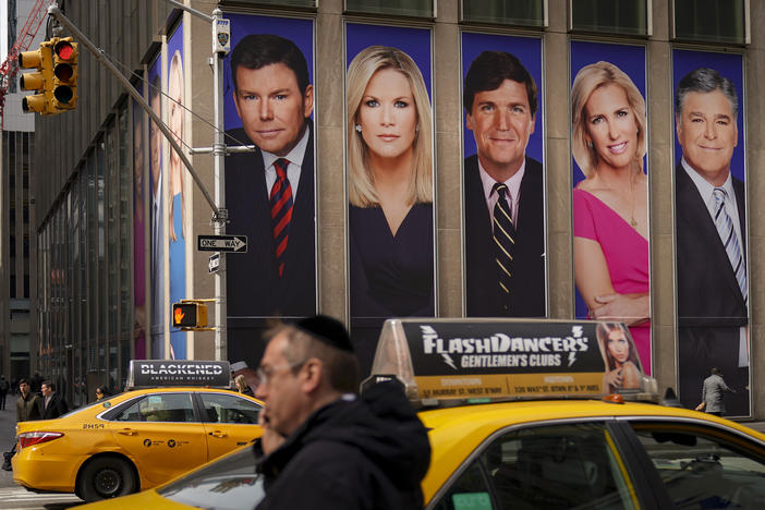 Posters bearing the images of Bret Baier, Martha MacCallum, Tucker Carlson, Laura Ingraham and Sean Hannity, from left, adorn the front of Fox Corp.'s headquarters in New York City. The stars' panic as viewers fled after the 2020 elections has become a core element of a $1.6 billion defamation suit against Fox.