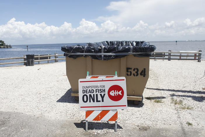 A sign is posted for depositing dead marine life from the "red tide" bacteria into dumpsters is seen at Bay Vista Park on July 21, 2021 in St Petersburg, Florida.