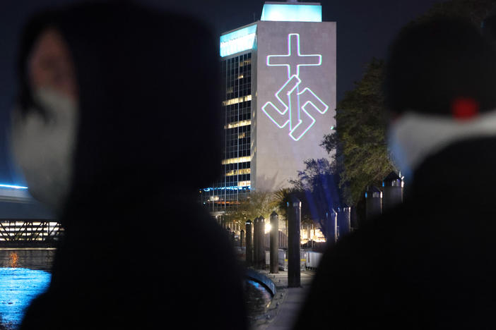 Members of the white nationalist group National Socialist Florida use a laser projector to display white nationalist and anti-LGBTQ images on the side of the CSX building and other high-rise buildings in Jacksonville, Fla.