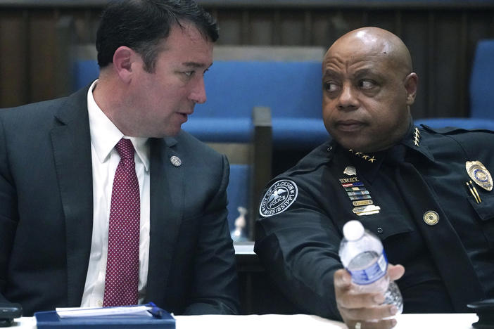 Mississippi Public Safety Commissioner Sean Tindell, left, confers with Jackson Police Chief James Davis during a town hall meeting to address youth crime issues in Jackson, Miss., Feb. 14, 2023.