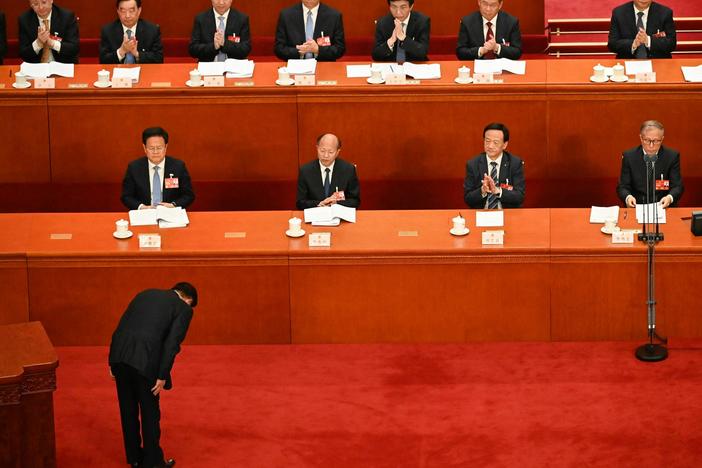 Chinese State Councilor and Secretary-General of the State Council Xiao Jie bows to delegates before delivering a speech during the second plenary session of the National People's Congress at the Great Hall of the People in Beijing on Tuesday.