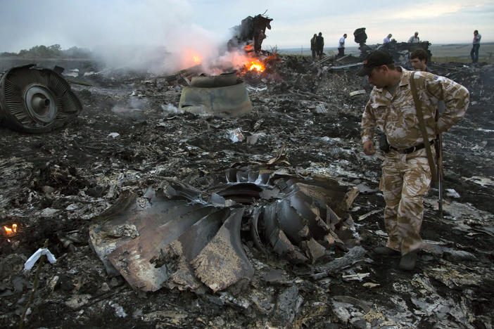 People walk amid the debris at the crash site of the Flight MH17 passenger plane near the village of Grabovo, Ukraine, on July 17, 2014.