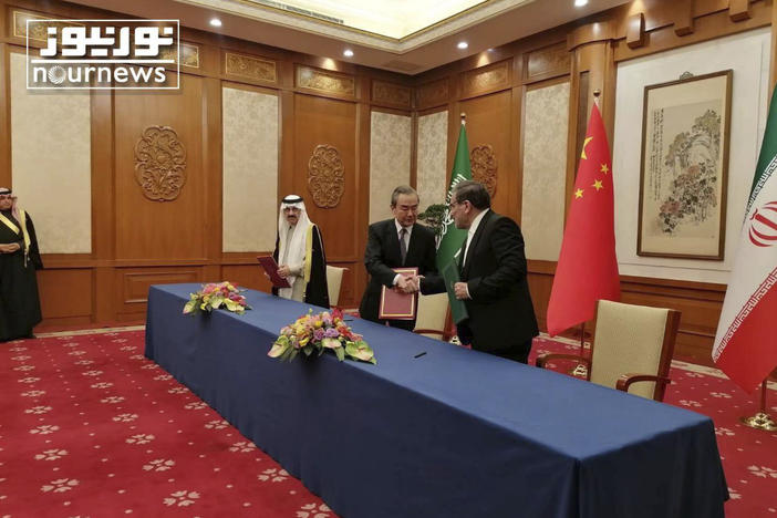 Secretary of Iran's Supreme National Security Council Ali Shamkhani (right) shakes hands with senior Chinese diplomat Wang Yi, as Saudi national security adviser Musaad bin Mohammed al-Aiban looks on during an agreement signing ceremony between Iran and Saudi Arabia to reestablish diplomatic relations and reopen embassies in Beijing, Friday.