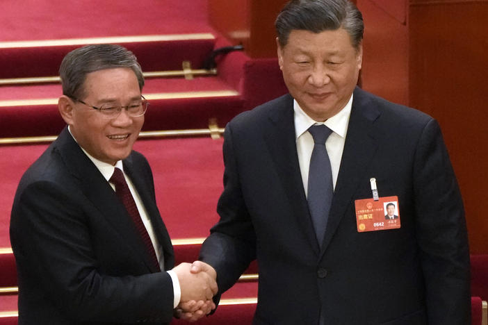 Newly elected Premier Li Qiang, left, shakes hands with Chinese President Xi Jinping during a session of China's National People's Congress in Beijing on Saturday.