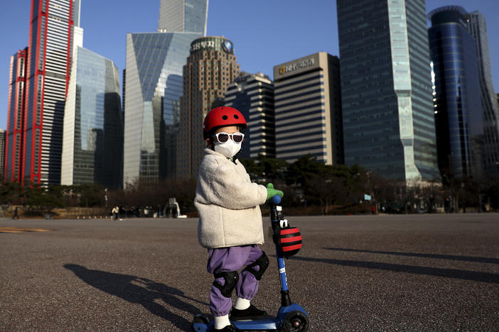A South Korean child masks up to ride a scooter on Feb. 27, 2020 in Seoul.