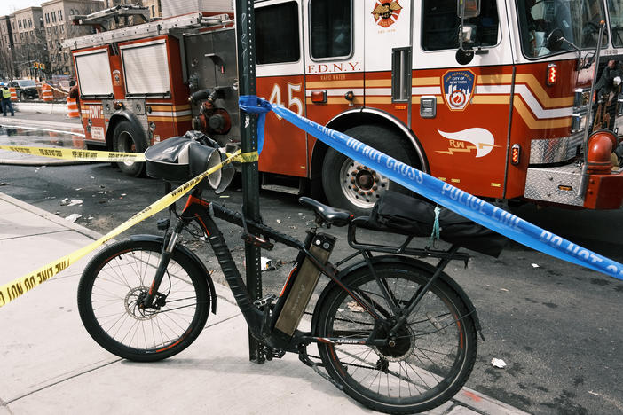 An electric bike parked near a Bronx supermarket that was destroyed in a fire that officials say was caused by a faulty lithium-ion scooter battery.