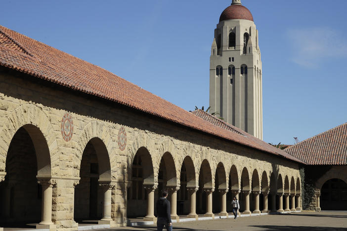 People walk on the Stanford University campus beneath Hoover Tower in Stanford, Calif., on March 14, 2019. Stanford University says it is investigating after multiple swastikas and an image of Adolf Hitler were found on a door Saturday at a Stanford student residence hall.