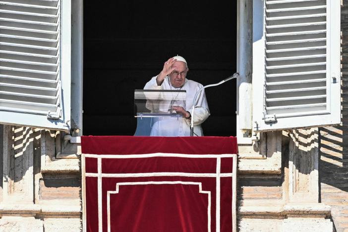 Pope Francis waves from the window of the apostolic palace during the weekly Angelus prayer on Sunday in the Vatican.