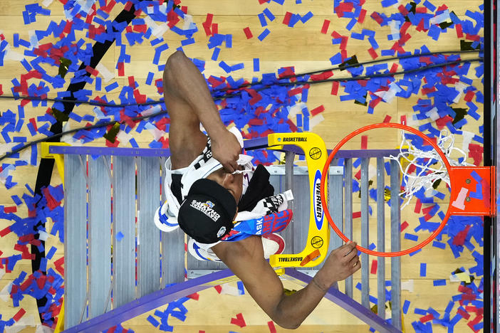 David McCormack of the Kansas Jayhawks cuts down the net after defeating the North Carolina Tar Heels in March Madness last year.