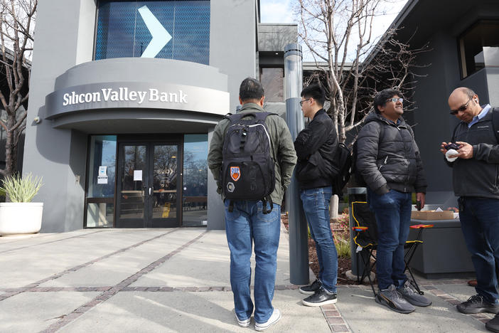 People line up outside of a Silicon Valley Bank office on Monday in Santa Clara, Calif. Days after Silicon Valley Bank collapsed, customers are lining up to try and retrieve their funds from the failed bank.