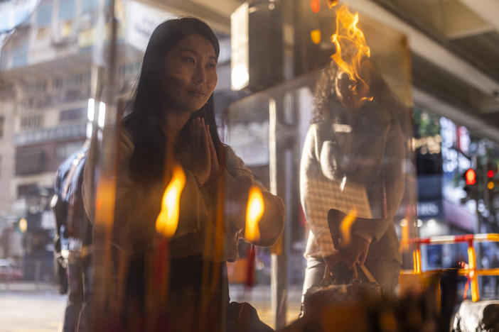 A customer prays during a "villain hitting" ceremony under the Canal Road Flyover in Hong Kong, on Sunday, March 5, 2023. People holding a grudge may have found a way to release it in Hong Kong's "villain hitting" ritual.