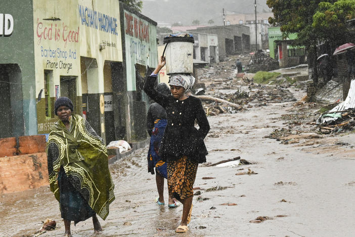 Women walk to a nearby displacement center in Blantyre, Malawi, on Tuesday. The unrelenting Cyclone Freddy, which is still battering southern Africa, has killed hundreds of people in Malawi and Mozambique since it struck the continent for a second time on Saturday night.