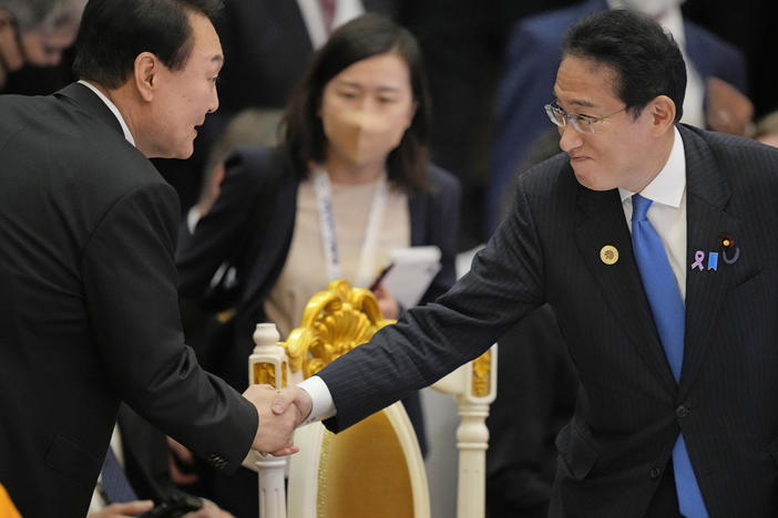 Japan's Prime Minister Fumio Kishida (right) shakes hands with South Korea's President Yoon Suk Yeol during the ASEAN summit in Phnom Penh, Cambodia, on Nov. 13, 2022. The two leaders will meet in Tokyo on Thursday in the first bilateral summit between Japan and South Korea in more than a decade, in hopes of overcoming tensions that date back more than 100 years.