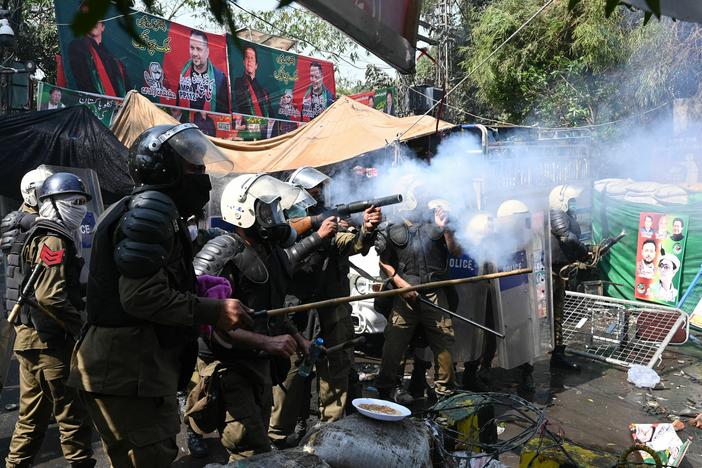 Riot police fire tear gas shells toward supporters of former Prime Minister Imran Khan gathered near Khan's house to prevent officers from arresting him, in Lahore, Pakistan, on Wednesday. The police withdrew later in the day.