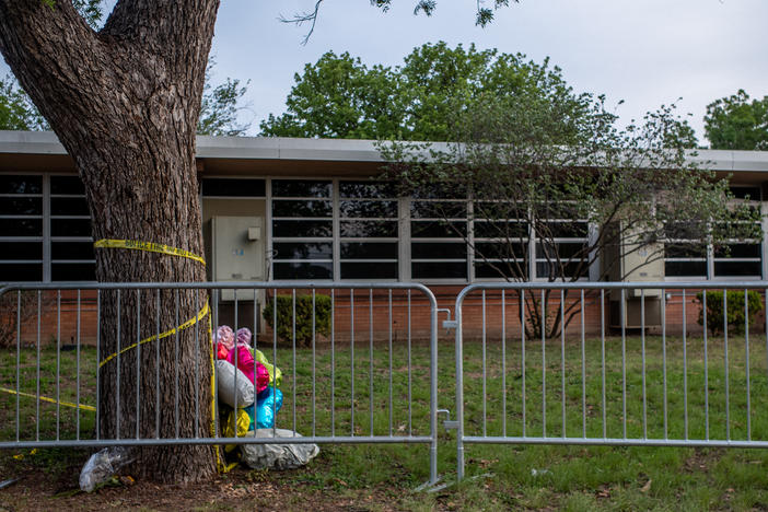Balloons are seen wrapped around a tree in caution tape at Robb Elementary School on May 31, 2022 in Uvalde, Texas, a week after the school shooting.