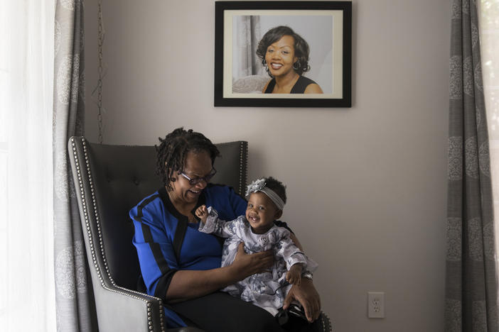 Wanda Irving holds her granddaughter, Soleil, in front of a portrait of Soleil's mother, Shalon Irving, at her home in Sandy Springs, Ga., in 2017. Wanda is raising Soleil since Shalon died of complications due to hypertension a few weeks after giving birth.