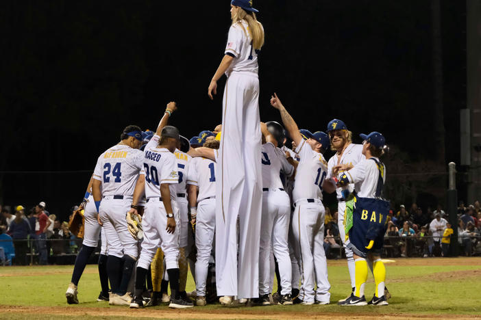 The Savannah Bananas huddle on the field at Grayson Stadium in Savannah, Georgia, before playing a team of retired Major League Baseball players on March 11, 2023.