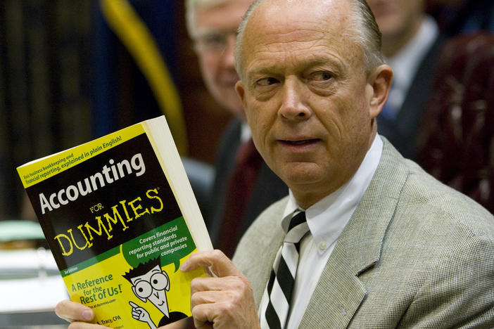 South Carolina Comptroller General Richard Eckstrom holds up a book he wanted to present to his new chief of staff during his introduction at a meeting on Aug. 13, 2009, in Columbia, S.C. Pressure is mounting for Eckstrom after a $3.5 billion accounting error.