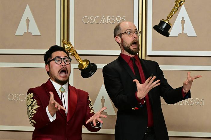 Directors Daniel Kwan (left) and Daniel Scheinert pose with their best director trophies for <em>Everything Everywhere All at Once.</em>