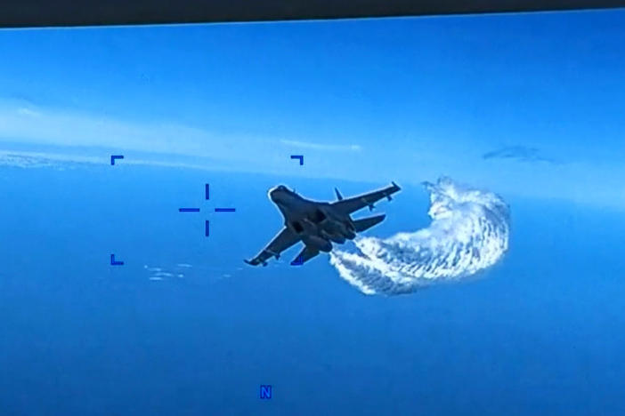 In a screen grab of a video clip released by the U.S. Defense Department's European Command, a Russian Su-27 fighter jet flies near a U.S. MQ-9 Reaper drone, spraying it with what appears to be jet fuel, on Mar. 14 over the Black Sea.