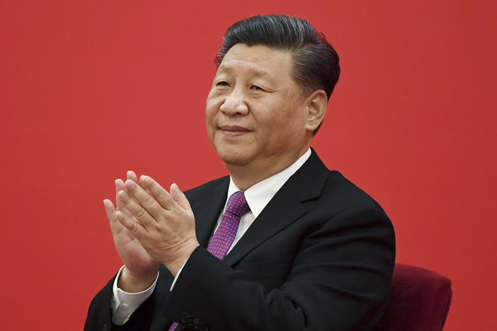 China's leader Xi Jinping claps as he listens to Russian President Vladimir Putin via a video link, from the Great Hall of the People in Beijing on Dec. 2, 2019. Xi will meet Putin this week on a visit to Moscow.