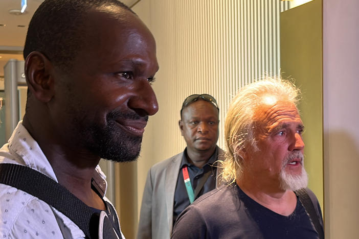 French journalist Olivier Dubois left, and Jeffery Woodke, right, are seen as they arrive at the Diori Hamani International Airport in Niamey on Monday.