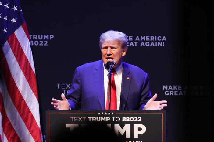 Former President Donald Trump, pictured here speaking to guests at Iowa's Adler Theatre last week, said on social media that he'll be arrested Tuesday as part of an investigation into hush money payments.