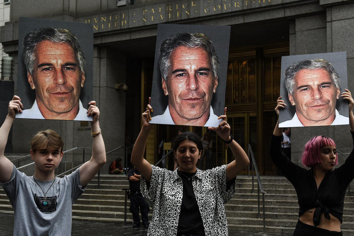 A group of protesters hold photos of Jeffrey Epstein in front of a New York City federal courthouse in July 2019. A Southern District judge ruled this week that three lawsuits against banks that Epstein used can move forward.